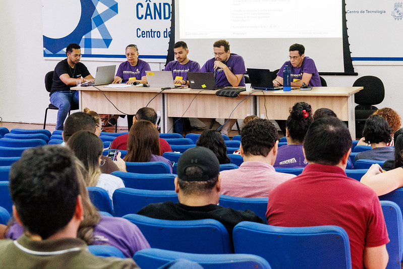 Delegados da Estatuinte sentados no auditório olhando para as pesssoas da comissão organizadora, que estavam posicionadas na mesa da última plenária, realizada no dia 30 de junho de 2026
