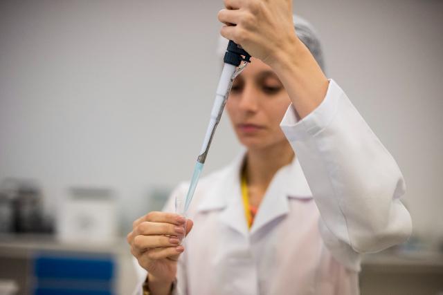 Imagem: mulher de jaleco branco pesquisa em laboratório