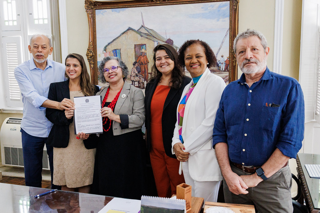 Imagem: Participantes da reuni&atilde;o sorriem e seguram o termo de apoio ao projeto Diagn&oacute;stico da Eros&atilde;o Costeira no Munic&iacute;pio de Jijoca de Jericoacoara (CE).