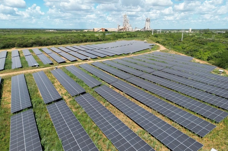 Foto de várias placas de energia solar em campo gramado