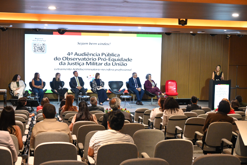 Grupo de pessoas em auditório sentadas e olhando para mesa de debatedores da audiência