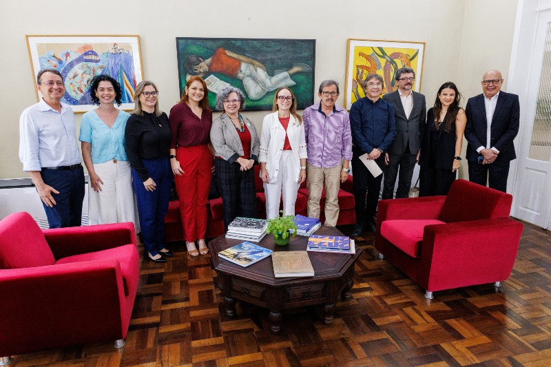 Reunião entre integrantes da UFC e do FNDE. Ao centro, a reitora em exercício da UFC, Diana Azevedo, de blazer cinza, e a presidente do FNDE, Fernanda Pacobahyba, de camisa e calça brancas, ao lado de demais participantes.