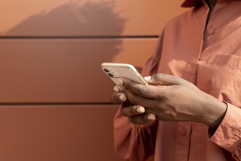 Fotografia mostra close de mãos de uma mulher segurando smartphone (Foto: Magnific)