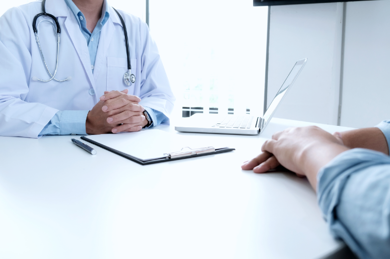M&eacute;dico sentado atendendo paciente