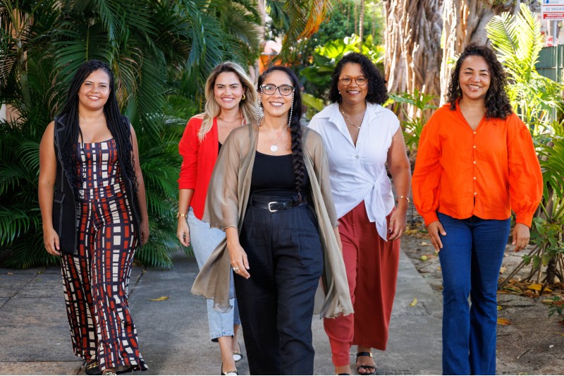 Cinco mulheres servidoras da UFC estão andando em direção à câmera, uma está à frente das demais
